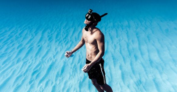 Snorkel - Unrecognizable man snorkeling in azure seawater