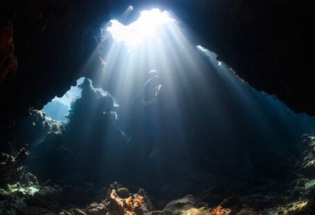 Diving - a sunbeam shines through a cave in the ocean