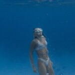 Snorkel - Full body of anonymous lady in swimsuit and flippers with snorkeling mask swimming undersea in clear blue water