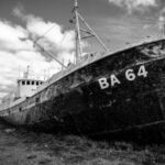 Sunken Ship - Grayscale Photography of Abandoned Cargo Ship on Field