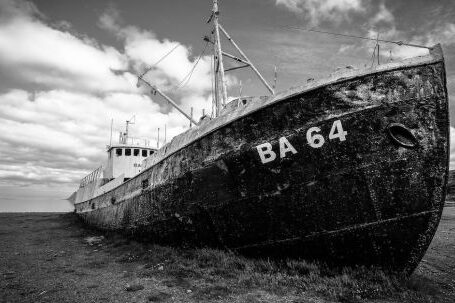 Sunken Ship - Grayscale Photography of Abandoned Cargo Ship on Field