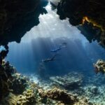 Diving Locations - a scuba diver swims through an underwater cave