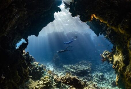 Diving Locations - a scuba diver swims through an underwater cave